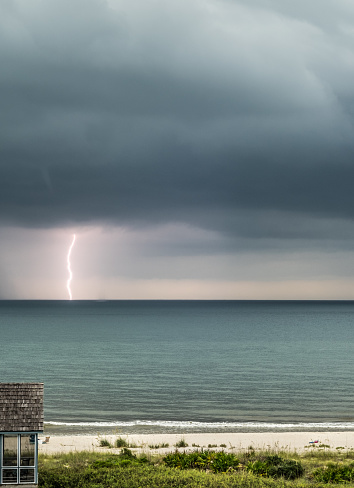 A lightening bolt stretches from the clouds to to the sea during a rain storm over the gulf coast.