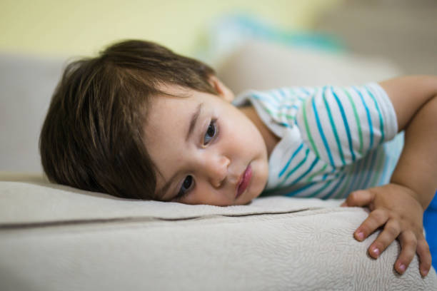 istock Cute little boy lying on bed 869009386