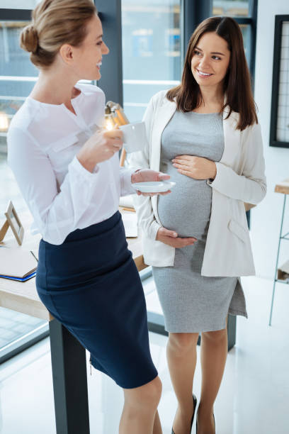 istock Smiling colleagues drinking tea in the office 869015874