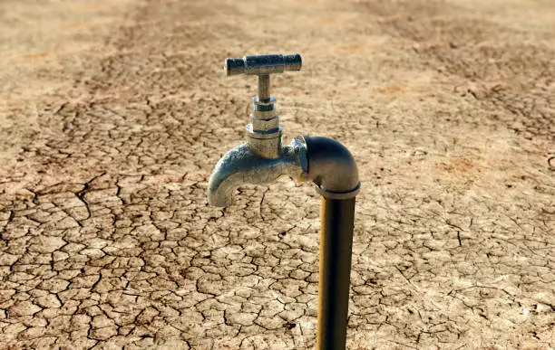 old metal water tap in dry surrounding.