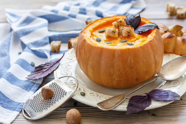 istock Pumpkin soup with spices and croutons in the pumpkin. 869017708