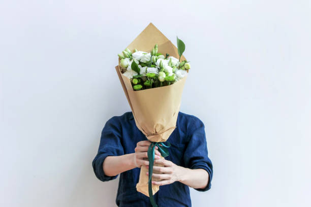 istock guy holding white flower bouquet 869026156