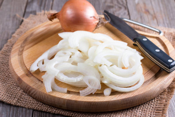 istock Chopped onions on wooden cutting board 869026354
