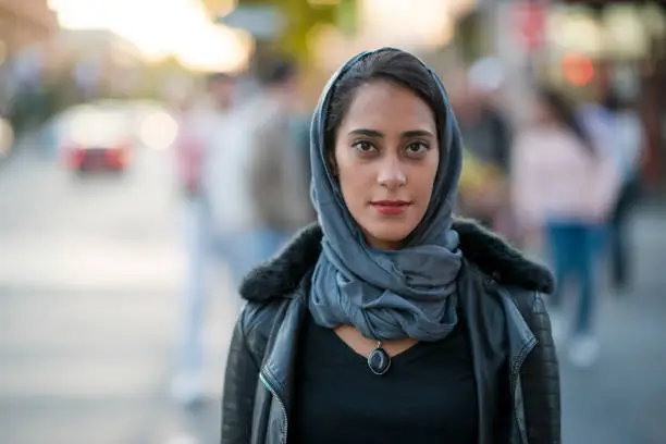 A beautiful Muslim woman wearing a hijab is skillfully navigating the city life.