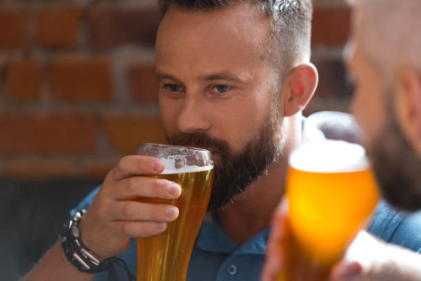 istock Men drinking beer in the pub, close up 869036758