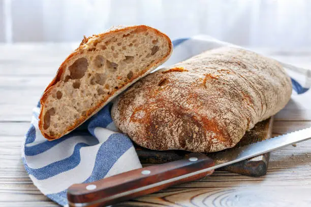 Traditional Italian bread on the kitchen table with a linen towel.