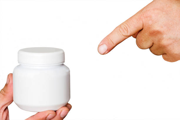 istock Index finger shows on Jar of cream 869044804
