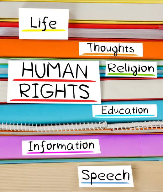 Photo of colorful book stack with bookmarks and labels with HUMAN RIGHTS conceptual words