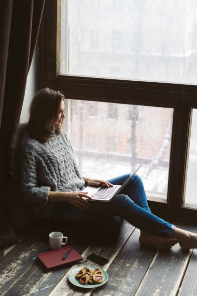 istock Young woman using laptop in a loft apartment 869048714