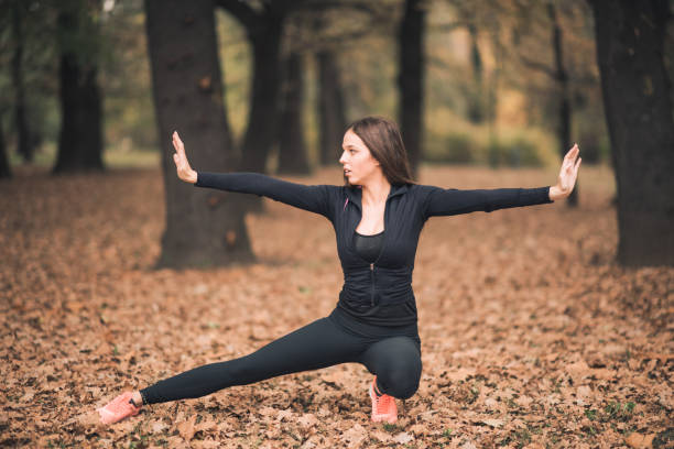 istock Woman practicing yoga in a semi-crouching position while spreading her hands horizontally 869050018