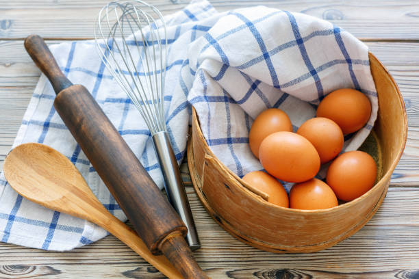 istock Kitchen utensils and brown eggs in an old sieve. 869057676