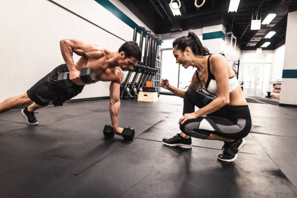 несколько фитнес-моделей делать отжимается - gym muscular build weights two people стоковые фото и изображения