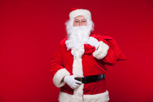 istock Christmas. santa claus with big bag on shoulder is on red background 869077232
