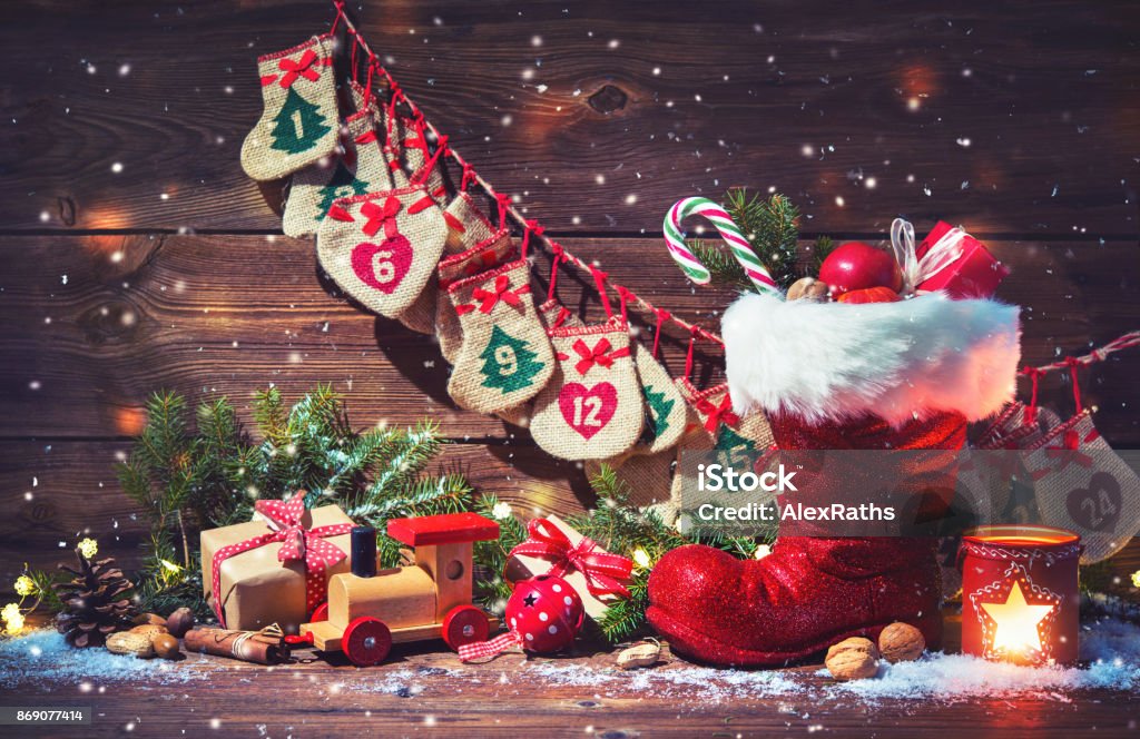 Calendario de Adviento y zapato de Santa con los regalos sobre fondo de madera rústico - Foto de stock de Papá Noel libre de derechos