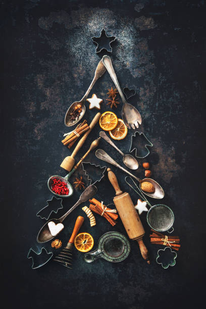 Christmas baking background Christmas baking background with fir tree made from kitchen utensils, cookies, spices, cinnamon sticks, anise stars on rustic baking tray, top view Christmas Tree Cookie stock pictures, royalty-free photos & images