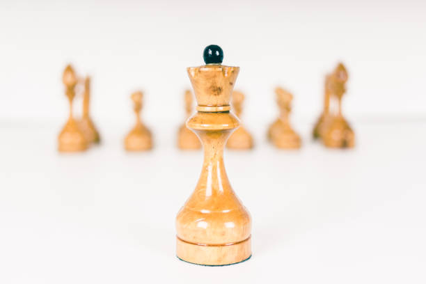 istock Simple old chess pieces - white queen and pawns 869078216