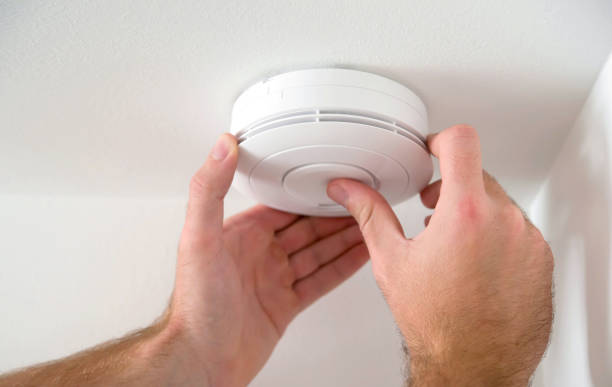 man installing smoke detector - alarm imagens e fotografias de stock