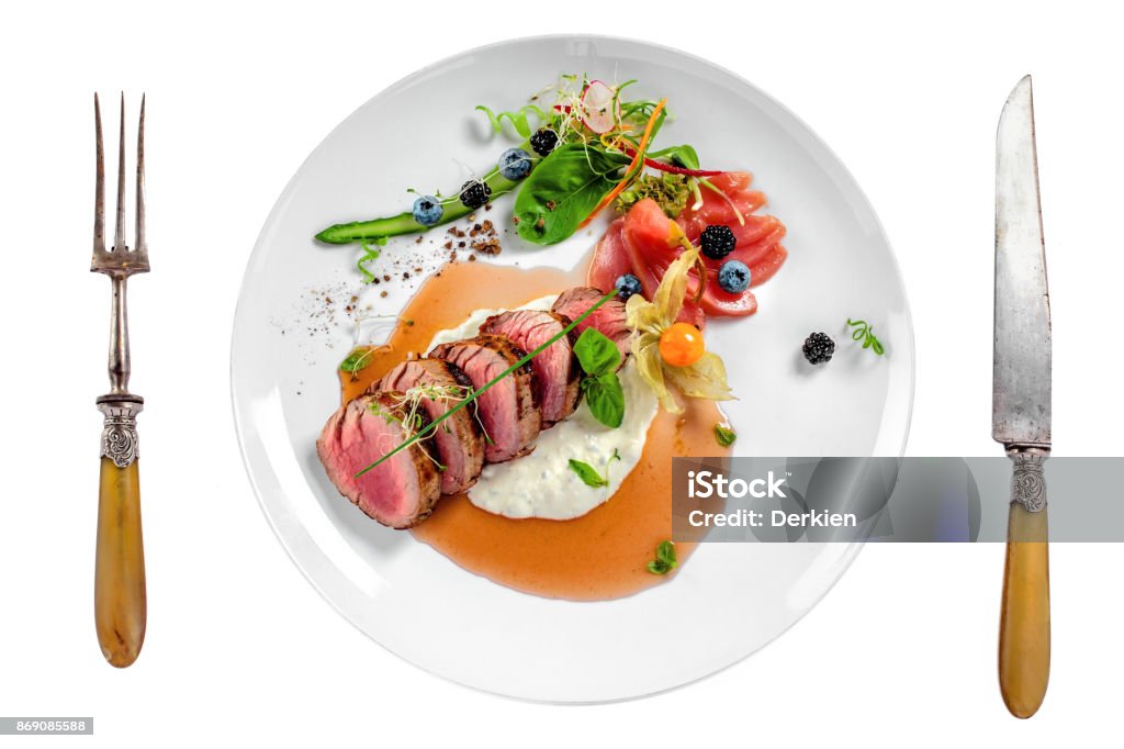 Medium rare meat steak Gourmet medium rare meat steak with sauce and fresh salad. Healthy meal made of meat fillet and fresh vegetables isolated on white background. Top view. Plate Stock Photo