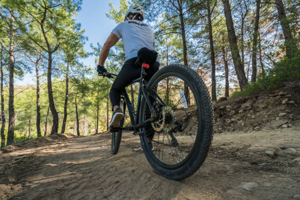 istock man mountainbiker rides on a sports bicycle on a forest trail. 869086030