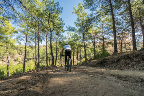 istock man mountainbiker rides on a sports bicycle on a forest trail. 869089330