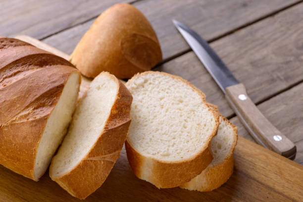 istock Sliced bread and knife. On wooden table 869095200