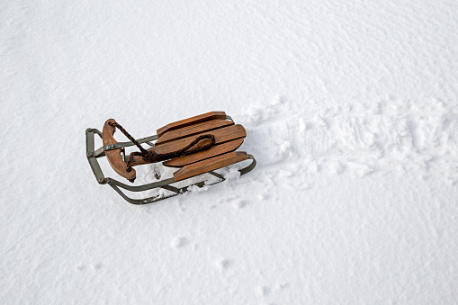 Small old-fashioned style sled in clean, freshly fallen snow.