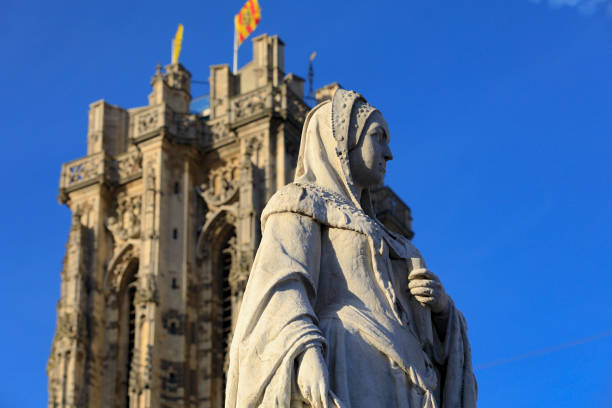 statue of Archduchess Margaret of Austria (1480-1530) by Belgian sculptor Joseph Tuerlinckx (1849) in the city centre of Mechelen with the tower of the St. Rumbold's Cathedral in the background; Mechelen, Belgium