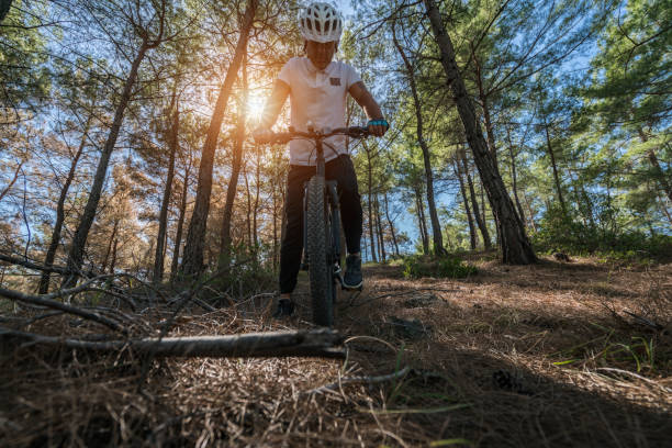 istock man mountainbiker rides on a sports bicycle on a forest trail. 869102514