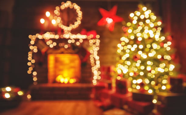 интерьер рождество. волшебное светящееся дерево, камин подарки в темноте - indoors inside of living room illuminated стоковые фото и изображения