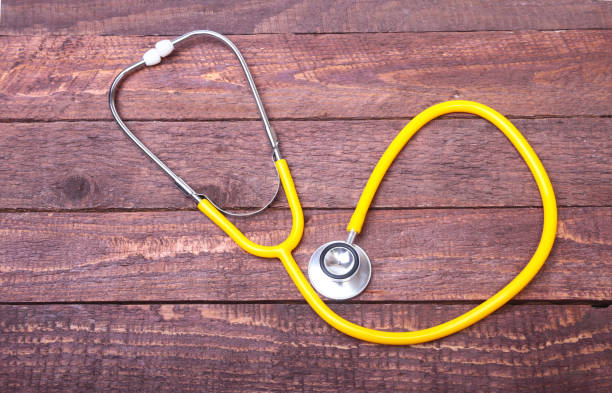 istock Medical stethoscope and tablets isolated on wooden background 869115568