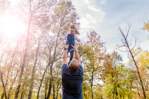 istock Playing with dad. Father having fun throws up in the air child 869122884