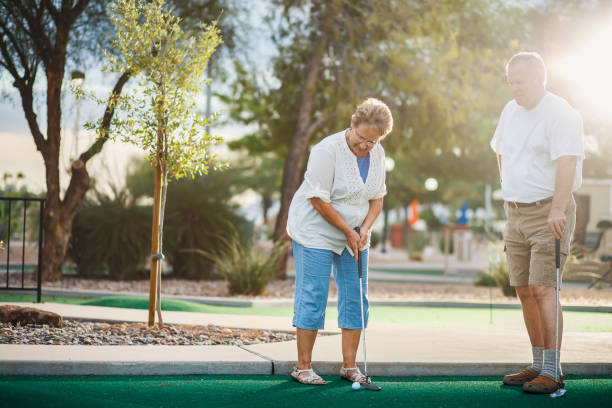 istock elderly couple playing mini golf shot with lens flare 869128270