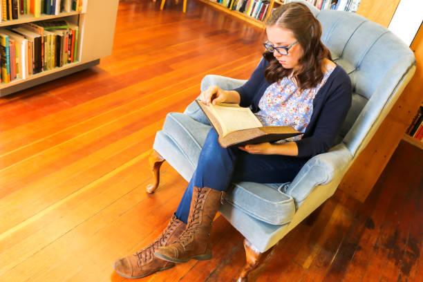 istock Young Girl Reading Book in the Library 869132112