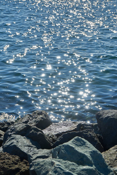 sun sparkles dancing on blue water stock photo
