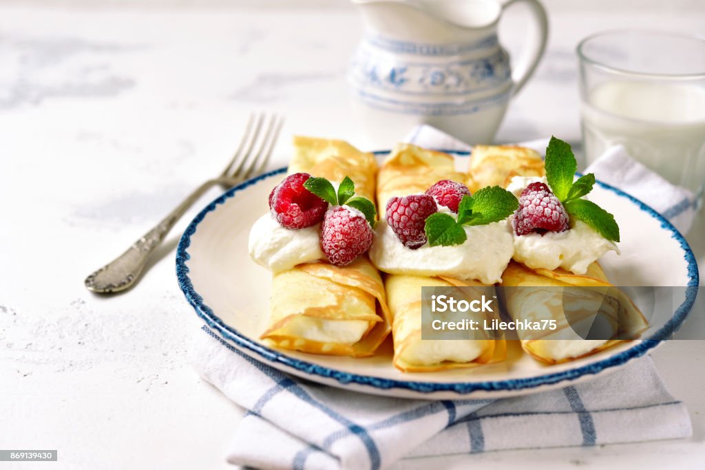 Crepes stuffed with ricotta Crepes stuffed with ricotta on a vintage plate on a light slate,stone or concrete background. Crêpe - Pancake Stock Photo