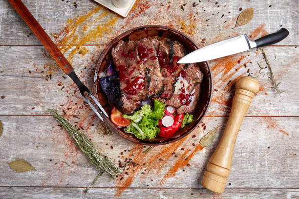 istock Authentic wooden plate with steak and vegetables and sauce 869139714
