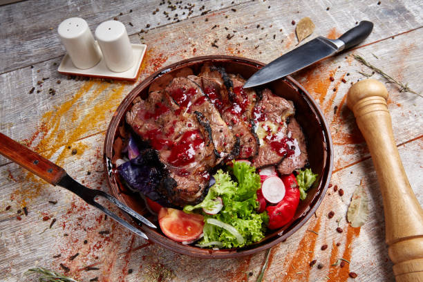 istock Authentic wooden plate with steak and vegetables and sauce 869139756