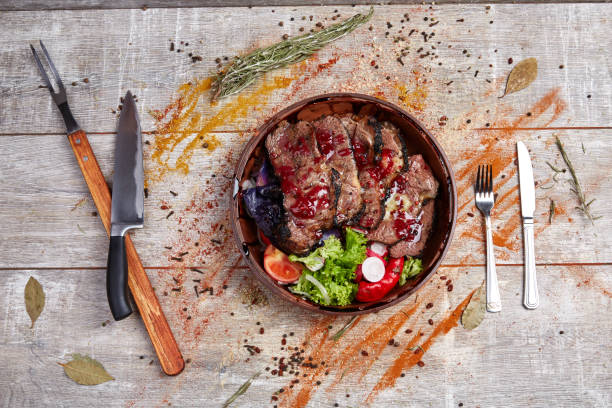 istock Authentic wooden plate with steak and vegetables and sauce 869142116