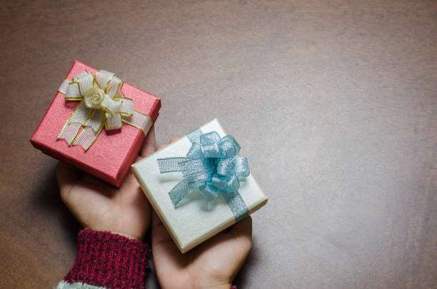 istock Gift box in hand on wooden background for giving 869152524