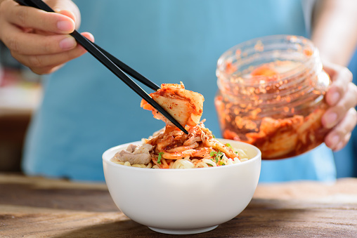 Korean food,instant noodle with kimchi cabbage in a bowl on wooden background