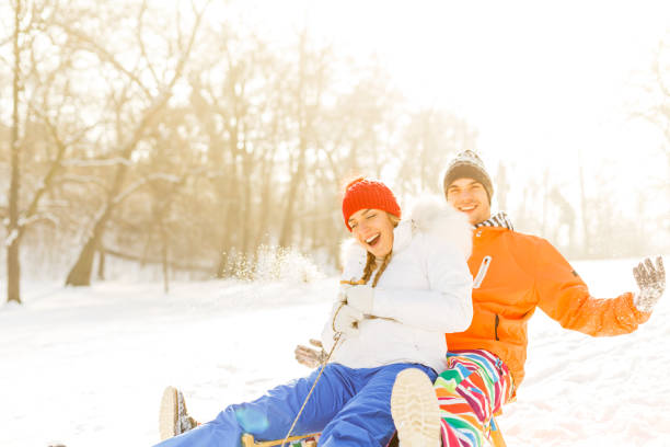 istock Couple sledding in snowy field 869160032