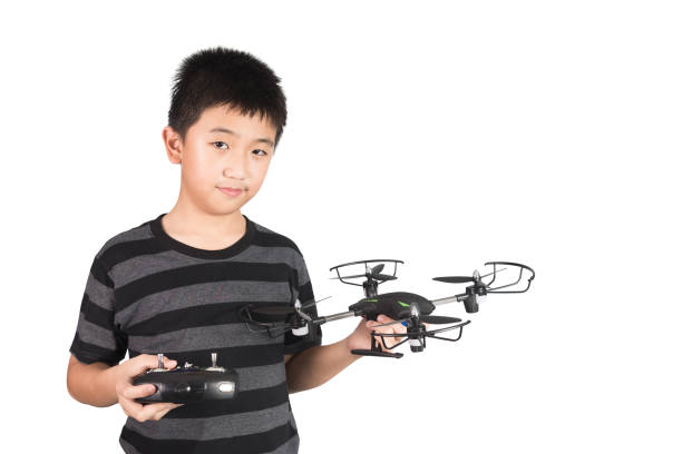 Asian boy holding drone and radio remote control (controlling handset) for helicopter, drone or plane, studio shot isolated on white background.