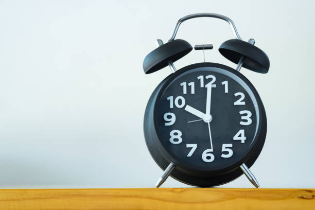 istock Black color vintage alarm clock on table with copy space, wake up time concept 869161016