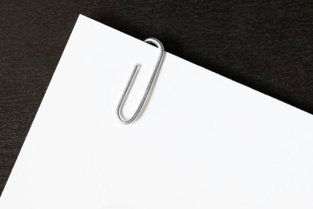 istock Paper Clip Paperclip On White Paper With Black Background 869167736