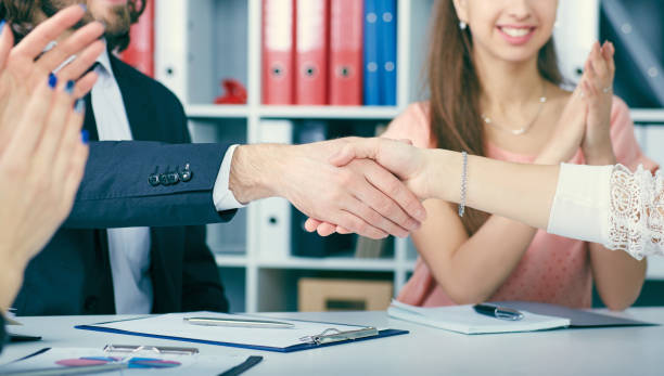 male and female handshake in office. serious business and partnership concept. partners made deal, sealed with handclasp. - hands clasped business education cooperation imagens e fotografias de stock