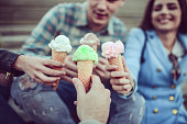 Smiling Friends Eating Ice Cream and Holding Cones in Hands