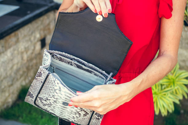 istock Closeup woman hands with fashion luxury snakeskin python handbag. Outdoors, Bali island 869178776