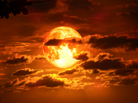 super moon on silhouette cloud in red tone sky, Elements of this image furnished by NASA