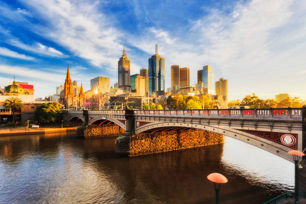 ME Princes Br sunlight Warm bright sunlight lit Melbourne city over Princes bridge St Kilda road sun sunrise over waters of Yarra river. yarra river stock pictures, royalty-free photos & images