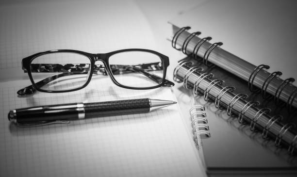 istock Glasses with pen and notebook on white background 869207416
